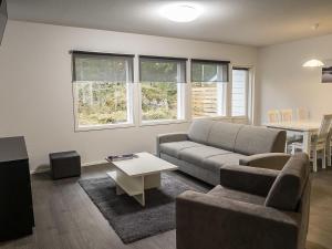 a living room with a couch and a table at Holiday Home Klz krysoliitti by Interhome in Vuokatti