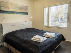 a bedroom with a bed with two towels on it at Holiday Home Klz krysoliitti by Interhome in Vuokatti +11 photos