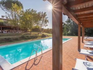 an outdoor swimming pool with a wooden pergola at Holiday Home Villa San Gervasio by Interhome in Castiglione del Bosco