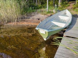 a blue boat sitting on a dock in the water at Holiday Home Kissankello by Interhome in Ahmovaara