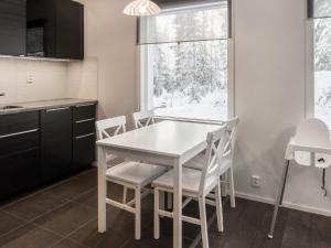 eine Küche mit einem weißen Tisch und Stühlen sowie einem Fenster in der Unterkunft Holiday Home Klz rodoniitti by Interhome in Vuokatti