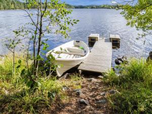 a boat is docked at a dock on a lake at Holiday Home Metsätähti by Interhome in Ahmovaara