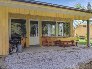 un porche delantero de una casa amarilla con parrilla en Holiday Home Lähtevä by Interhome, en Varistaipale