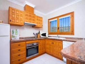 een keuken met houten kasten en een witte koelkast bij Villa Manana by Interhome in Moraira