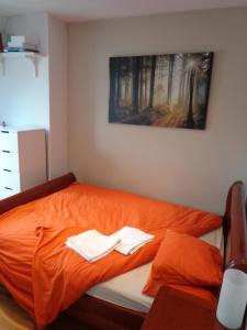 sypialnia z pomarańczowym łóżkiem i 2 ręcznikami w obiekcie SmartRooms, private apart - not shared! Top Quality, 10 w Paryżu