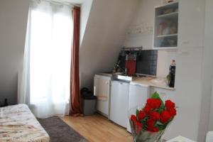 a kitchen with a vase of red roses on a table at SmartRooms, private apart - not shared! Top Quality, 10 in Paris