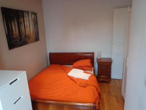 1 dormitorio con 1 cama con colcha de color naranja en SmartRooms, private apart - not shared! Top Quality, 10 en París
