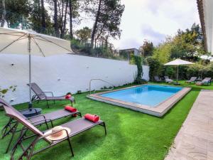 a swimming pool with two chairs and an umbrella at Holiday Home Paradis by Interhome in Mont Barbat