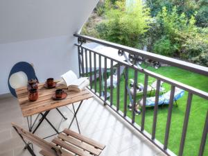 a balcony with a wooden table and a book at Holiday Home Paradis by Interhome in Mont Barbat