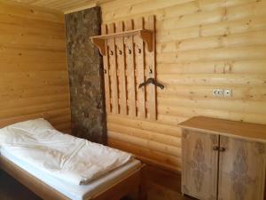 1 dormitorio con 1 cama y pared de madera en Біла хата, en Iltsi