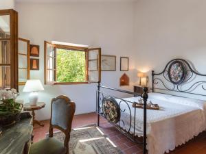 a bedroom with a bed and a table and a window at Holiday Home Villa San Gervasio by Interhome in Castiglione del Bosco