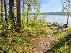 a path next to a body of water with a bench at Holiday Home Kissankello by Interhome in Ahmovaara