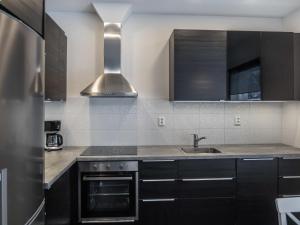 a kitchen with black cabinets and a sink at Holiday Home Klz rodoniitti by Interhome in Vuokatti