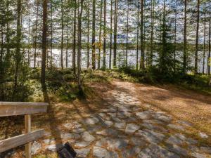 eine Holzbank neben einem Wasserkörper in der Unterkunft Holiday Home Metsätähti by Interhome in Ahmovaara