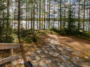 um banco de madeira sentado ao lado de uma massa de água em Holiday Home Metsätähti by Interhome em Ahmovaara