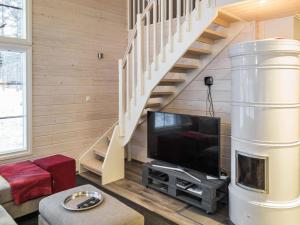 a living room with a tv and a staircase at Holiday Home Maaruska a by Interhome in Äkäslompolo