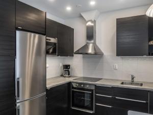 a kitchen with black cabinets and a stainless steel refrigerator at Holiday Home Klz rodoniitti by Interhome in Vuokatti