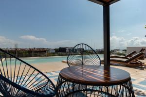 - une table et des chaises à côté de la piscine dans l'établissement Riva 202, à Playa del Carmen