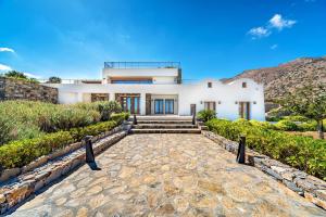 a house with a stone walkway in front of it at Elounda Lavender Villa in Elounda