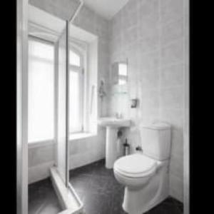 biała łazienka z toaletą i oknem w obiekcie galata west hostel w Stambule