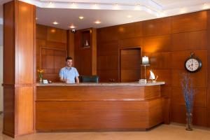 a man standing at a reception counter in a hotel lobby at Hotel Kaiser Bridge in Benitses