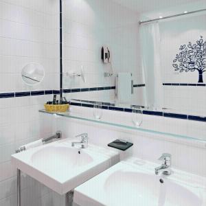 a white bathroom with two sinks and a mirror at Hotel König von Ungarn in Vienna