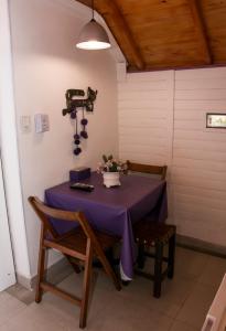 una mesa con un mantel púrpura y flores en ella en Cabañas La Maria Lourdes en Tafí del Valle