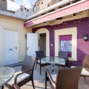 a patio with tables and chairs and a purple building at galata west hostel in Istanbul