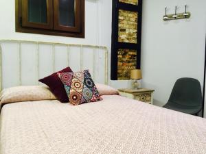 Una cama con dos almohadas encima. en La Guarida del Fraile, en Granada