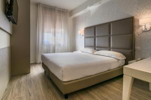 a bedroom with a large white bed and a window at Hotel Globo in Formigine