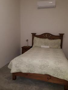 um quarto com uma cama e uma cabeceira em madeira em Hotel Purisima Concepción em Landa de Matamoros