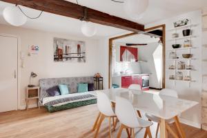a living room with a table and chairs and a couch at Le Grand Mirebeau - Parking privé in Bourges