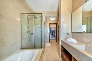 a bathroom with a shower and a tub and a sink at Elounda Lavender Villa in Elounda +33 photos