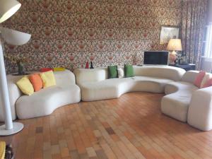 un soggiorno con divano bianco e cuscini colorati di Villa Suk a Taormina