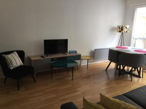 a living room with a tv and a table and chairs at PETIT STUDIO SYMPA EN CENTRE VILLE in Le Touquet-Paris-Plage