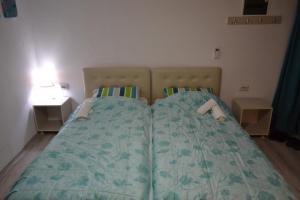 two beds in a small bedroom with two night stands at Honey Home by KOSTOSKI INN in Prilep