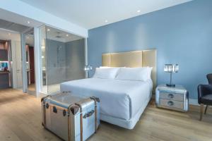 a hotel room with a bed and a dresser at NH Collection Santiago Casacostanera in Santiago