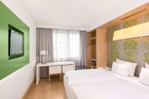 Postel nebo postele na pokoji v ubytování NH Berlin Potsdamer Platz