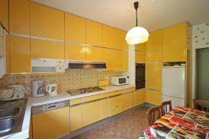eine Küche mit gelben Schränken und einem Tisch darin in der Unterkunft La Halte des Princes in Chantraine