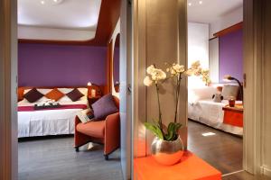 una habitación de hotel con un jarrón con flores en una mesa en Hotel Mediolanum en Milán