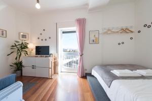 um quarto com uma cama e uma janela com uma varanda em All in flat by, city center, skyline no Porto