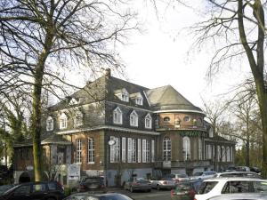 a large building with cars parked in front of it at Hotel Casino im Park in Kamp-Lintfort