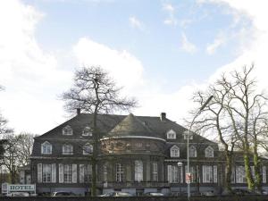 a large brown building with a large roof at Hotel Casino im Park in Kamp-Lintfort