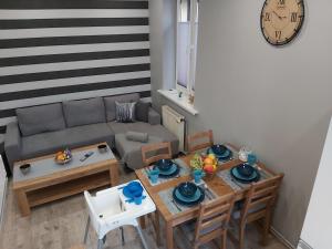 salon ze stołem i kanapą w obiekcie Apartament Na Franciszkańskiej w Szklarskiej Porębie