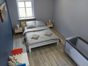 - une petite chambre avec un lit et une fenêtre dans l'établissement Apartament Na Franciszkańskiej, à Szklarska Poręba