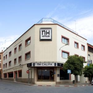 un gran edificio blanco con un cartel. en NH Córdoba Califa en Córdoba