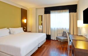 a hotel room with a large bed and a desk at iStay by NH Zaragoza Sport Hotel in Zaragoza