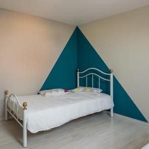 a bedroom with a bed with a blue and white wall at Maison Loiseau - Maison Calme au Centre de Beaune in Beaune