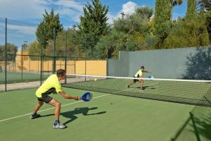 two men playing tennis on a tennis court at Alfagar Alto da Colina in Albufeira