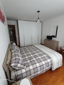 GiustinoにあるSnow Home Apartment - CIPAT 022093-AT-381181のベッドルーム1室(チェック入りの毛布付きのベッド1台付)